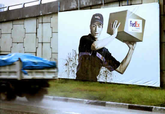 フェデックスの屋外広告。配送スタッフが身を挺し荷物を守ってます。大切に扱うアピールですね。＜フィリピン＞