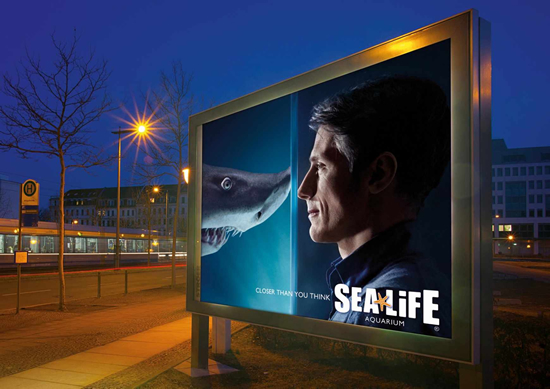 水族館（Sea Life Aquarium）の屋外広告。「あなたが思うよりも近いです。」とサメとの距離から、場所の利便性を伝えています。＜ドイツ＞